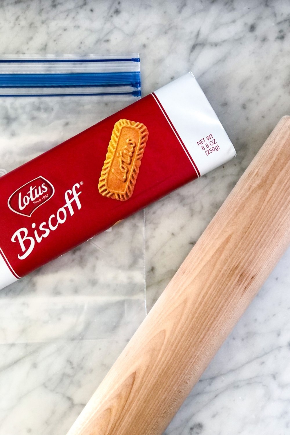 a package of lotus biscoff cookies next to a rolling pin