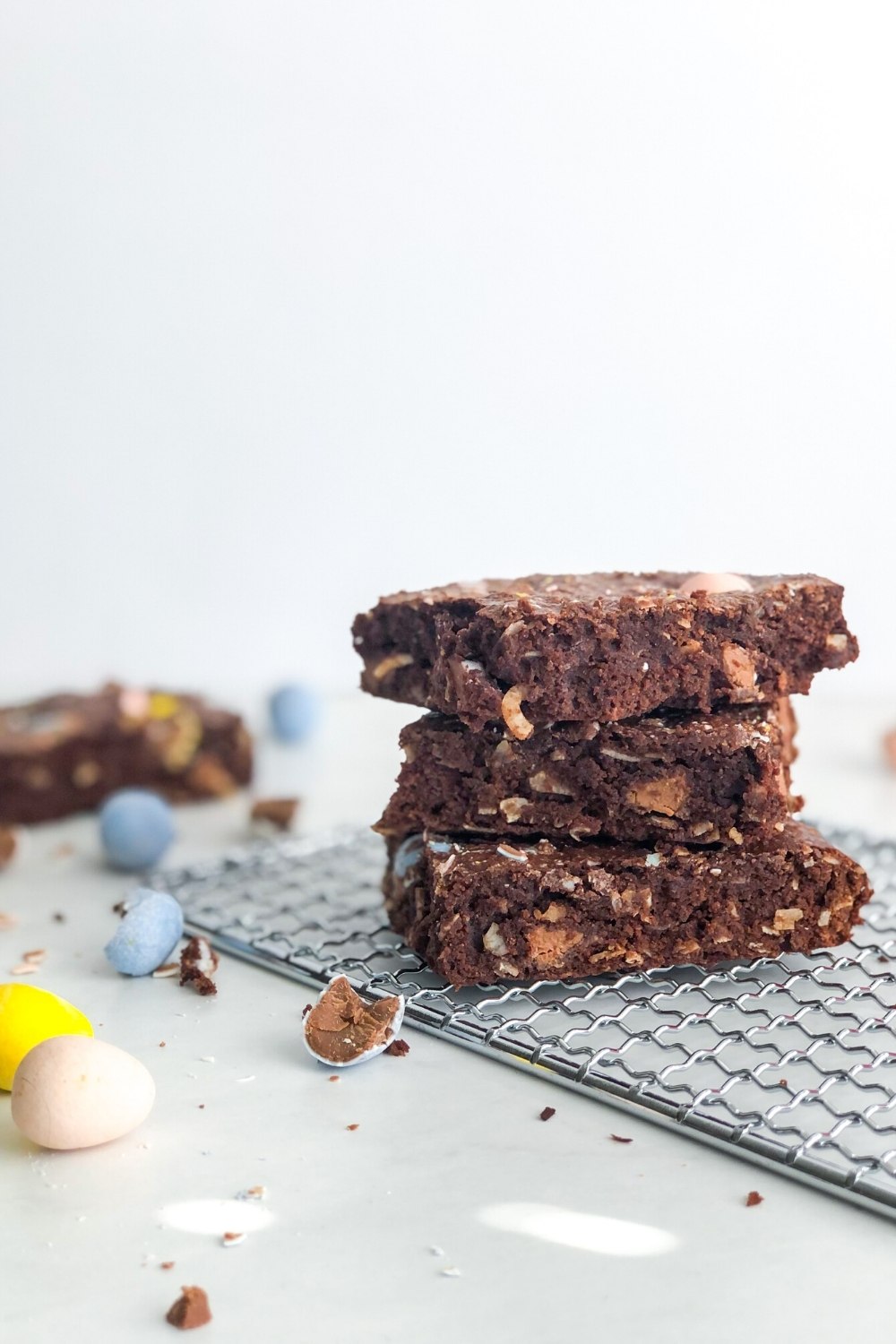 a stack of coconut brownies with cadbury mini eggs