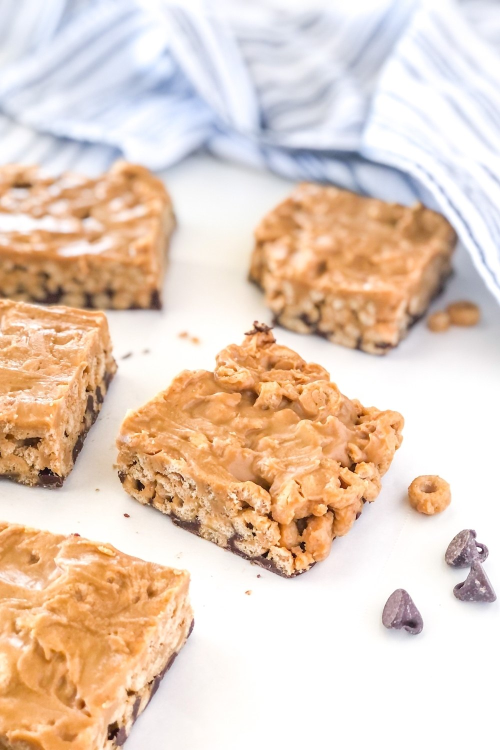 chocolate peanut butter cereal bars with a striped kitchen towel