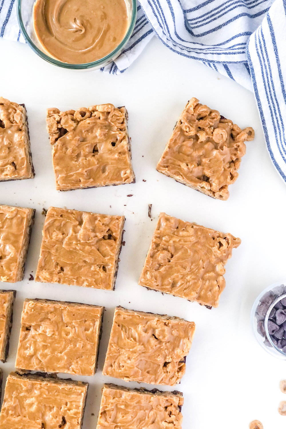 sliced peanut butter chocolate cheerio bars with a bowl of peanut butter