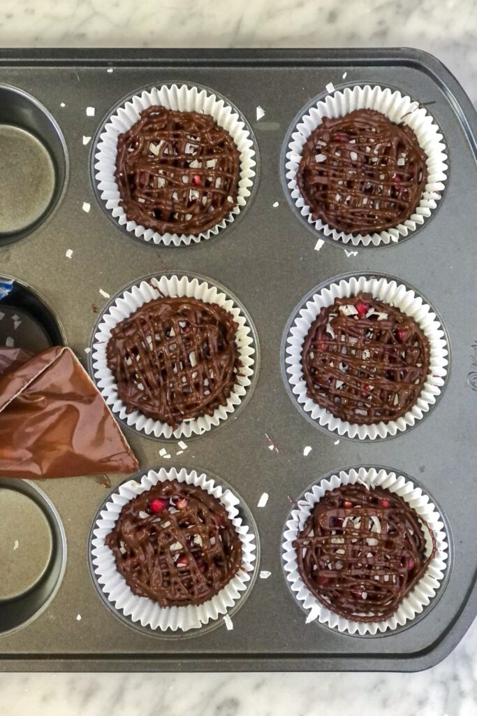 dark chocolate pomegranate bites in a muffin tin