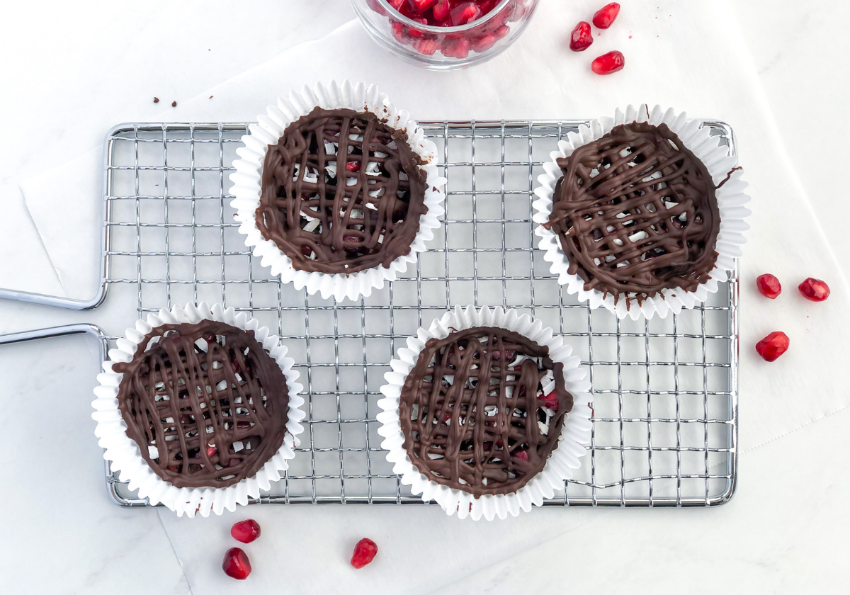 chocolate cups filled with pomegranate seeds and coconut in cupcake liners