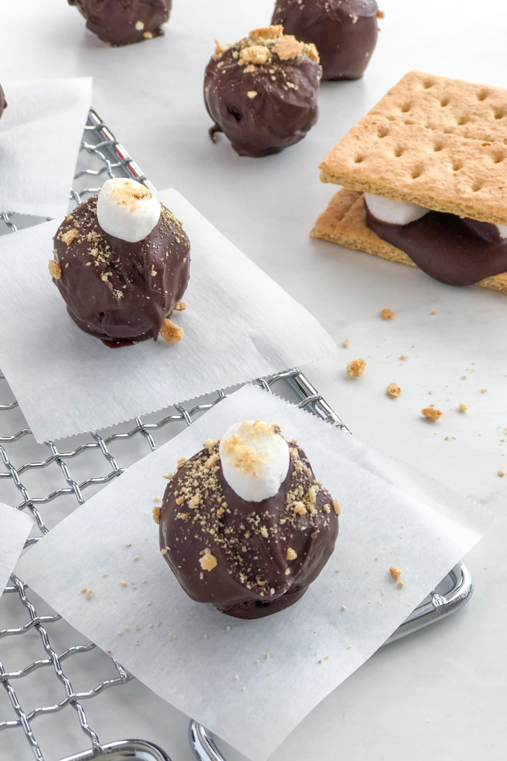 marshmallow smores truffles on a cooling rack with wax paper