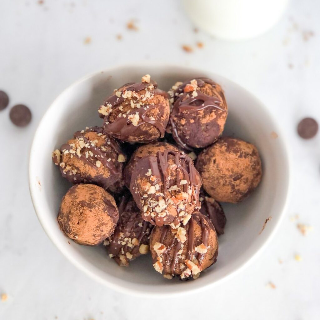 a white bowl filled with fudgy avocado chocolate truffles