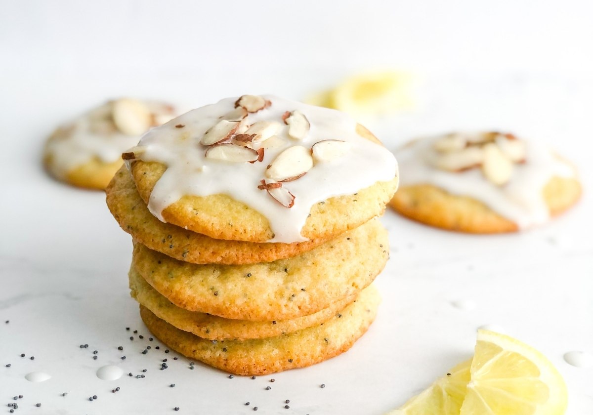 iced mascarpone cookies in a stack next to lemon wedges