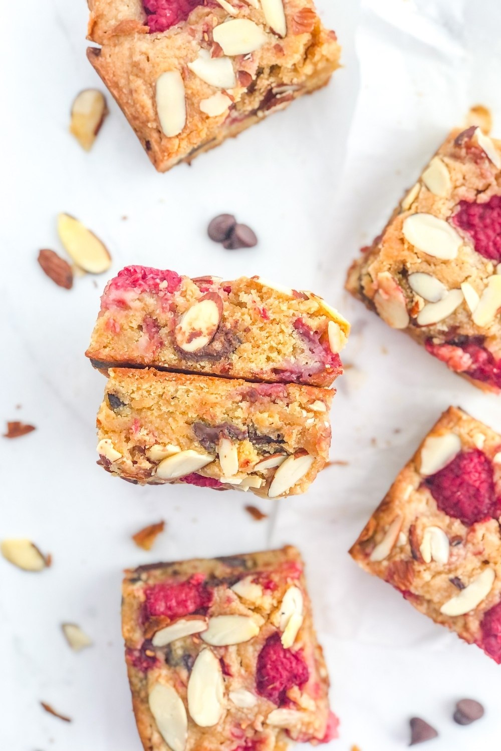 raspberry blondies with almonds and dark chocolate chips on parchment paper