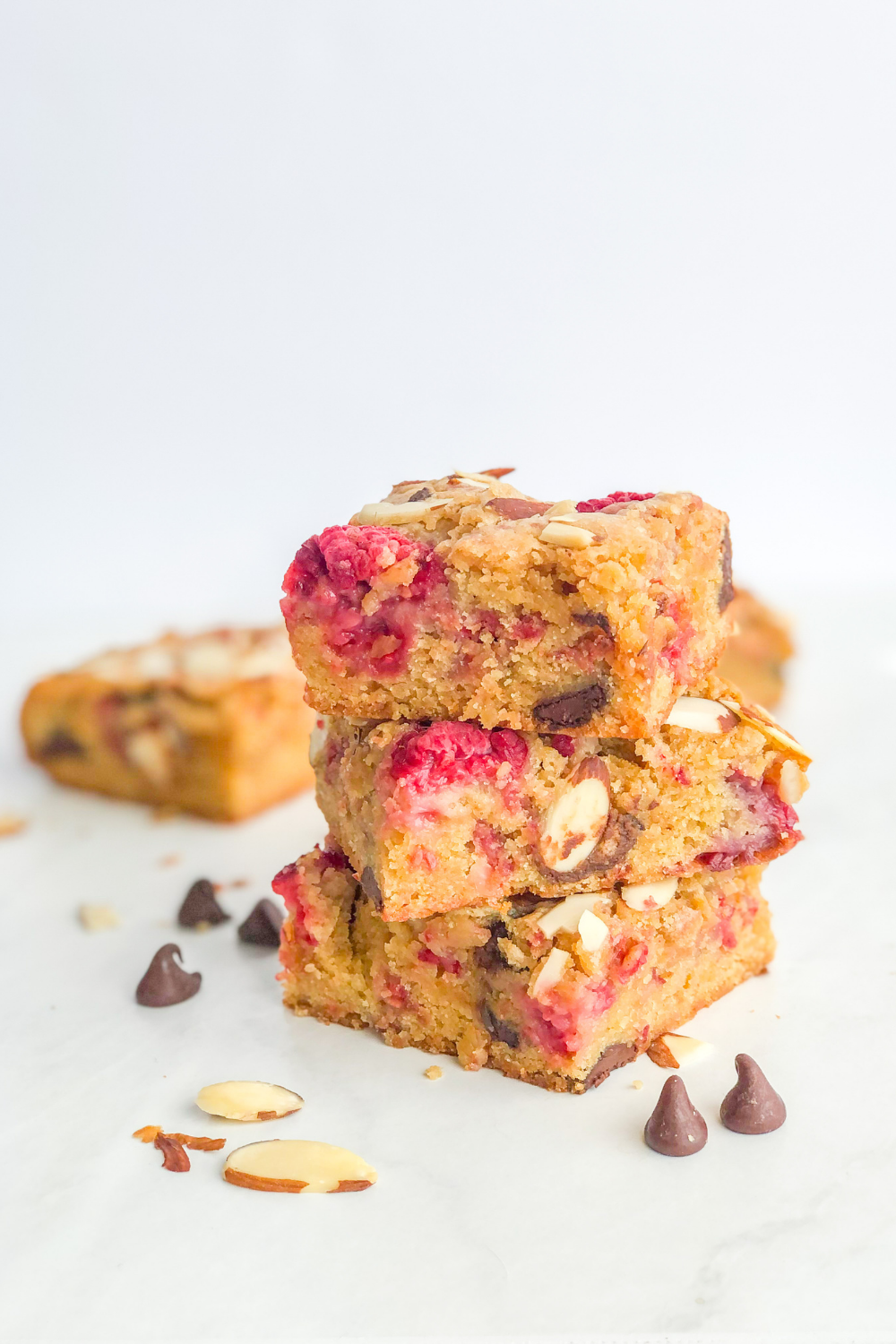 stack of raspberry almond blondies with dark chocolate chips