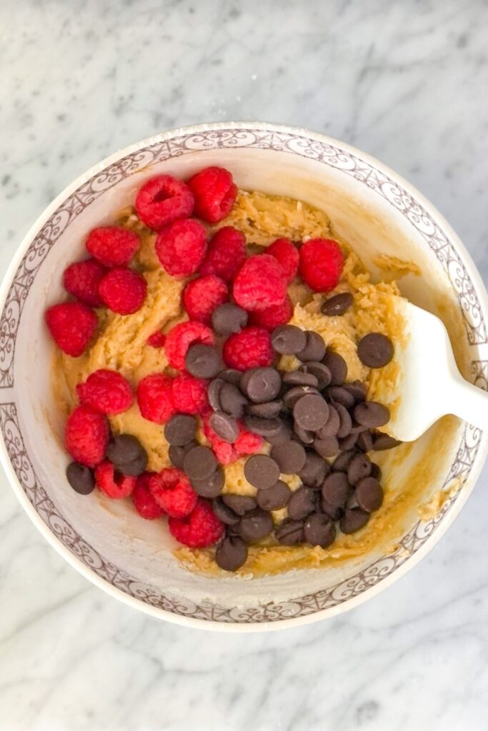 raspberries and dark chocolate chips in a bowl with batter