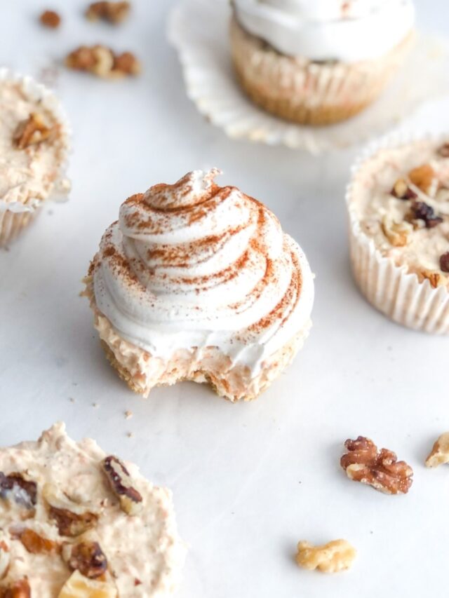 mini carrot cake cheesecakes topped with whipped cream and cinnamon