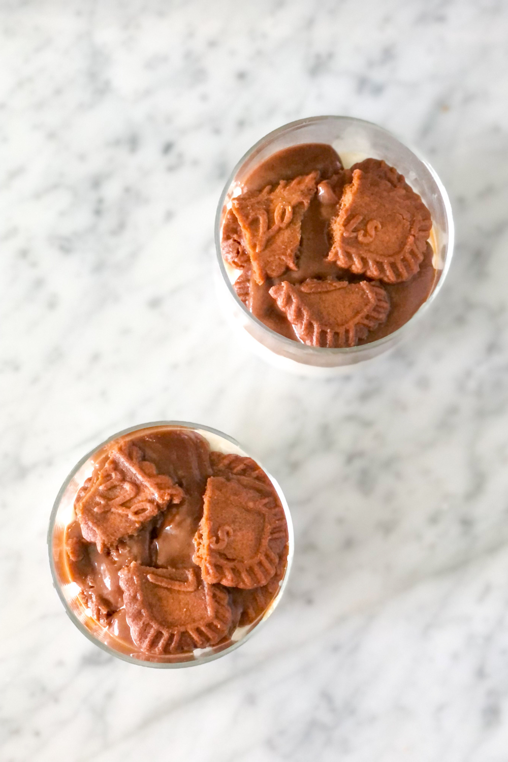 Biscoff spread and Biscoff cookies dipped in coffee layered over tiramisu cream in small jars