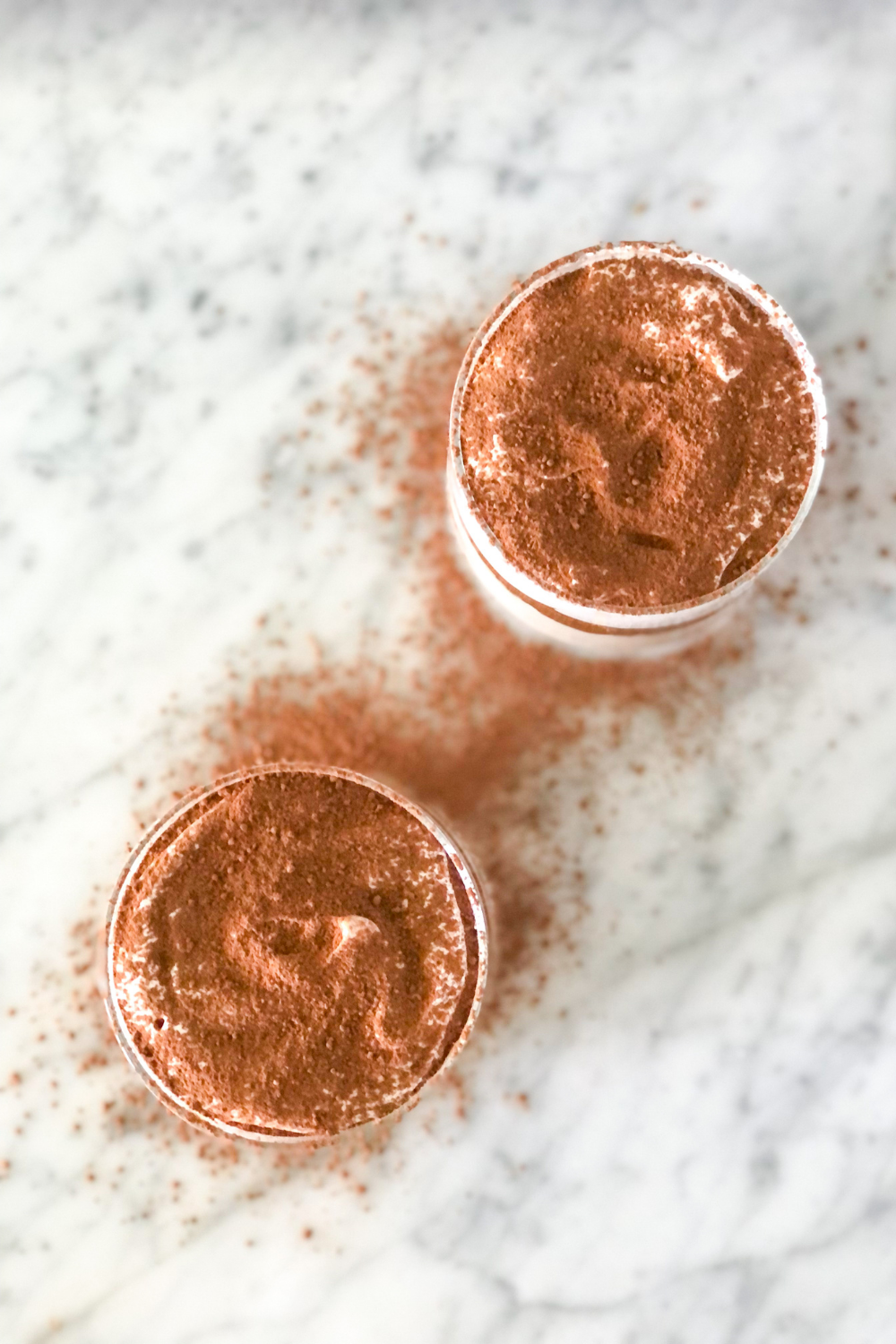 tiramisu cups topped with cocoa powder and espresso powder