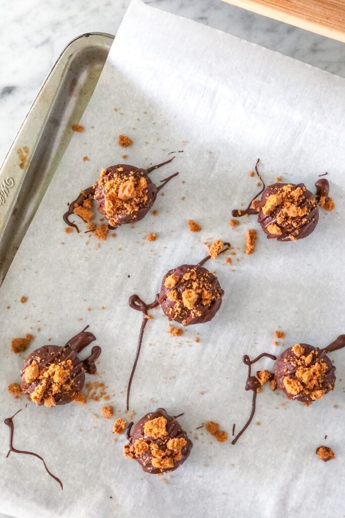 brownie truffles with chocolate drizzle and crushed Biscoff cookies on top