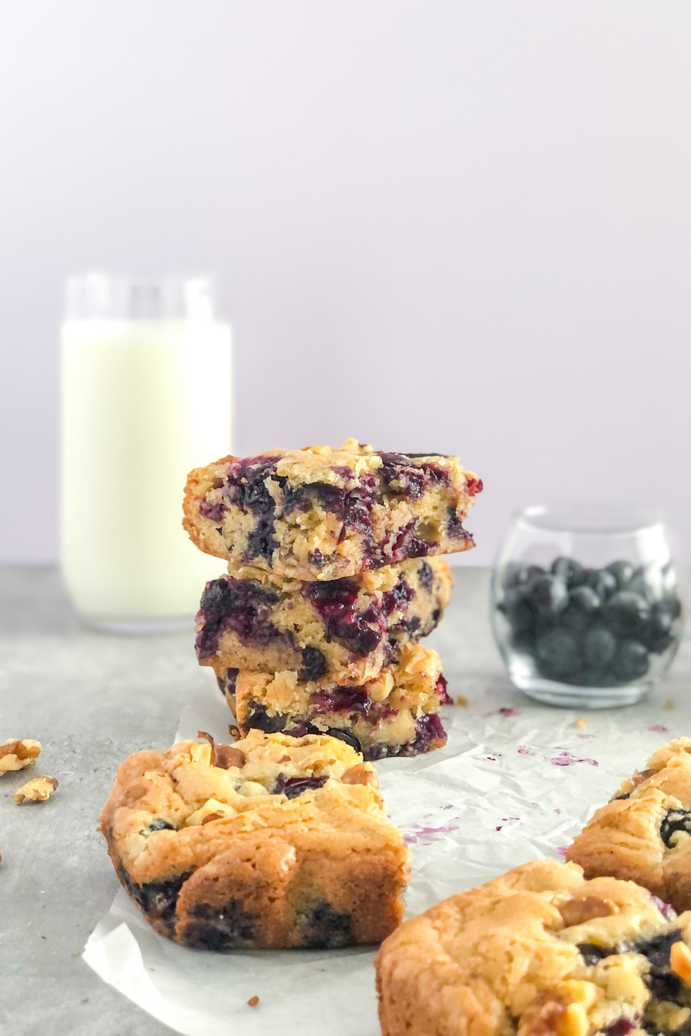 stack of blueberry walnut bars with a glass of milk