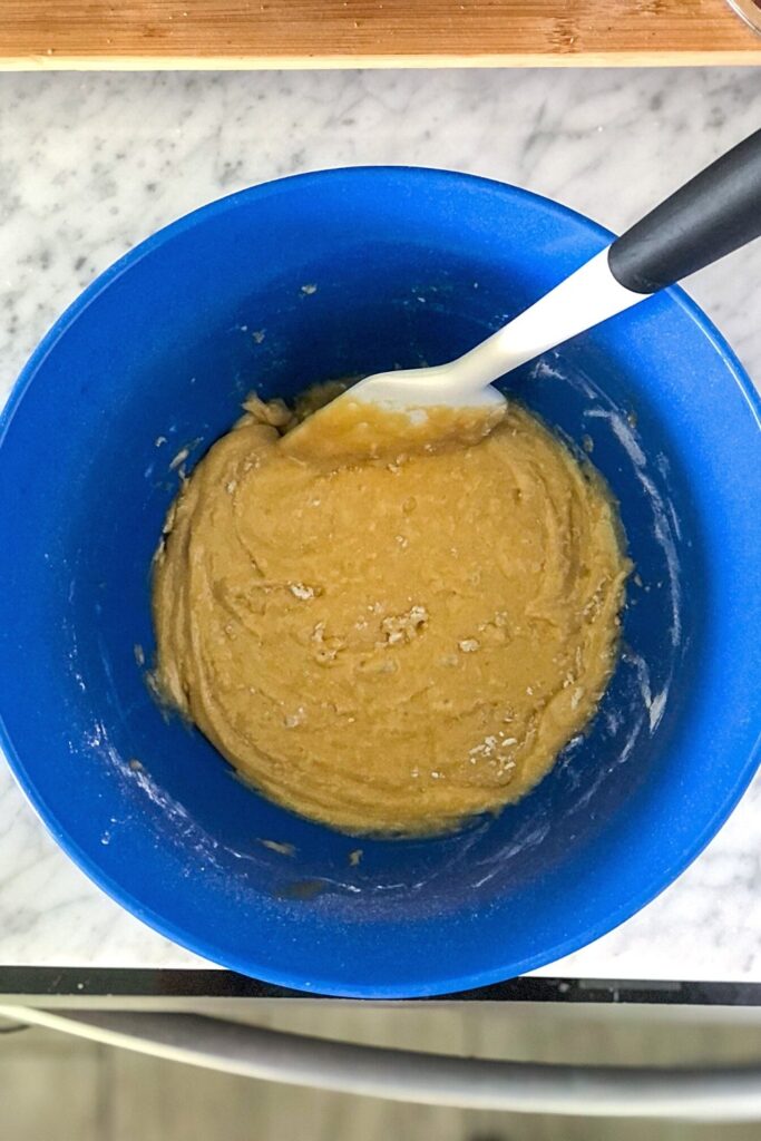 blondie batter in a blue mixing bowl with a white spatula