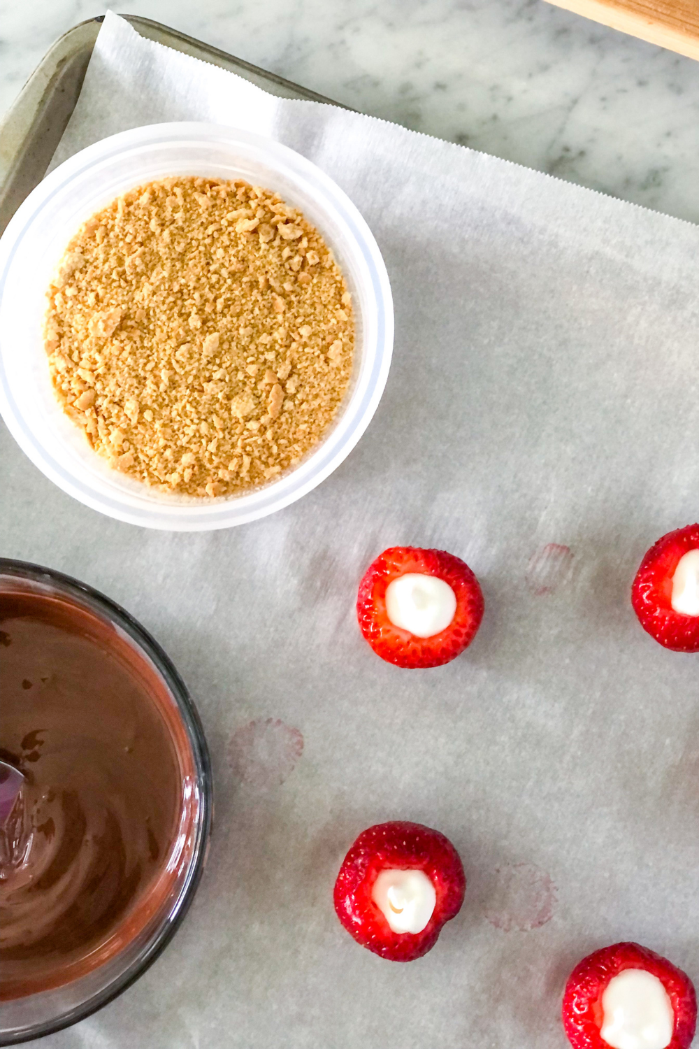 crushed graham crackers and melted chocolate with Nutella in bowls next to strawberries