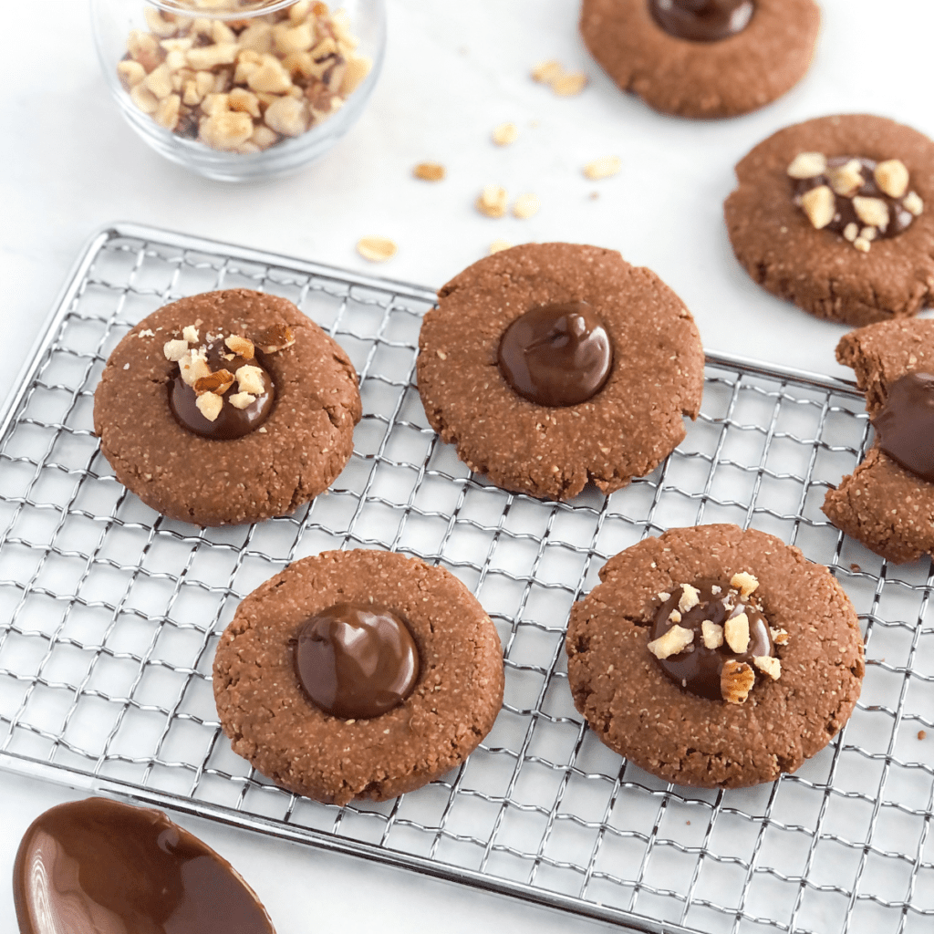 no bake chocolate thumbprint cookies with Nutella centers sitting on a metal cooling rack