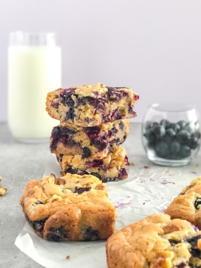 stack of blueberry walnut bars with a glass of milk