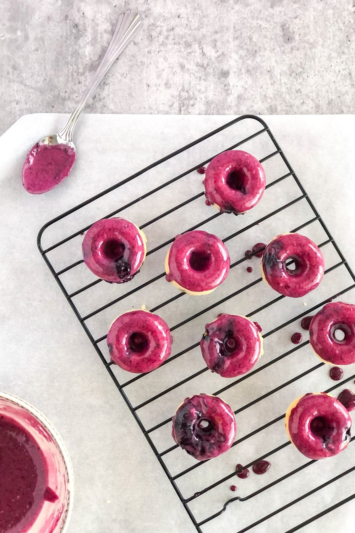 blueberry glazed mini donuts on a cooling rack