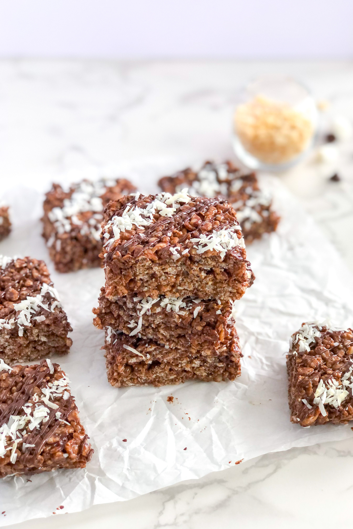 a stack of chocolate rice krispie treats on parchment paper