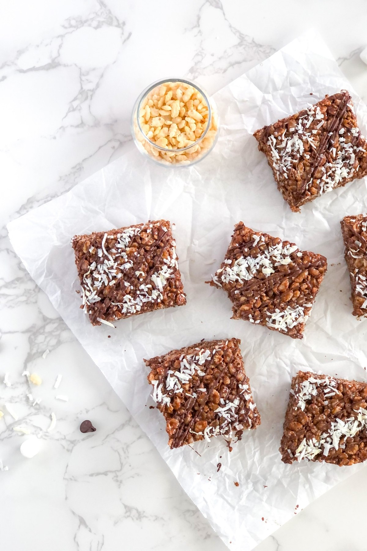 chocolate rice krispie treats with coconut on crinkled parchment paper