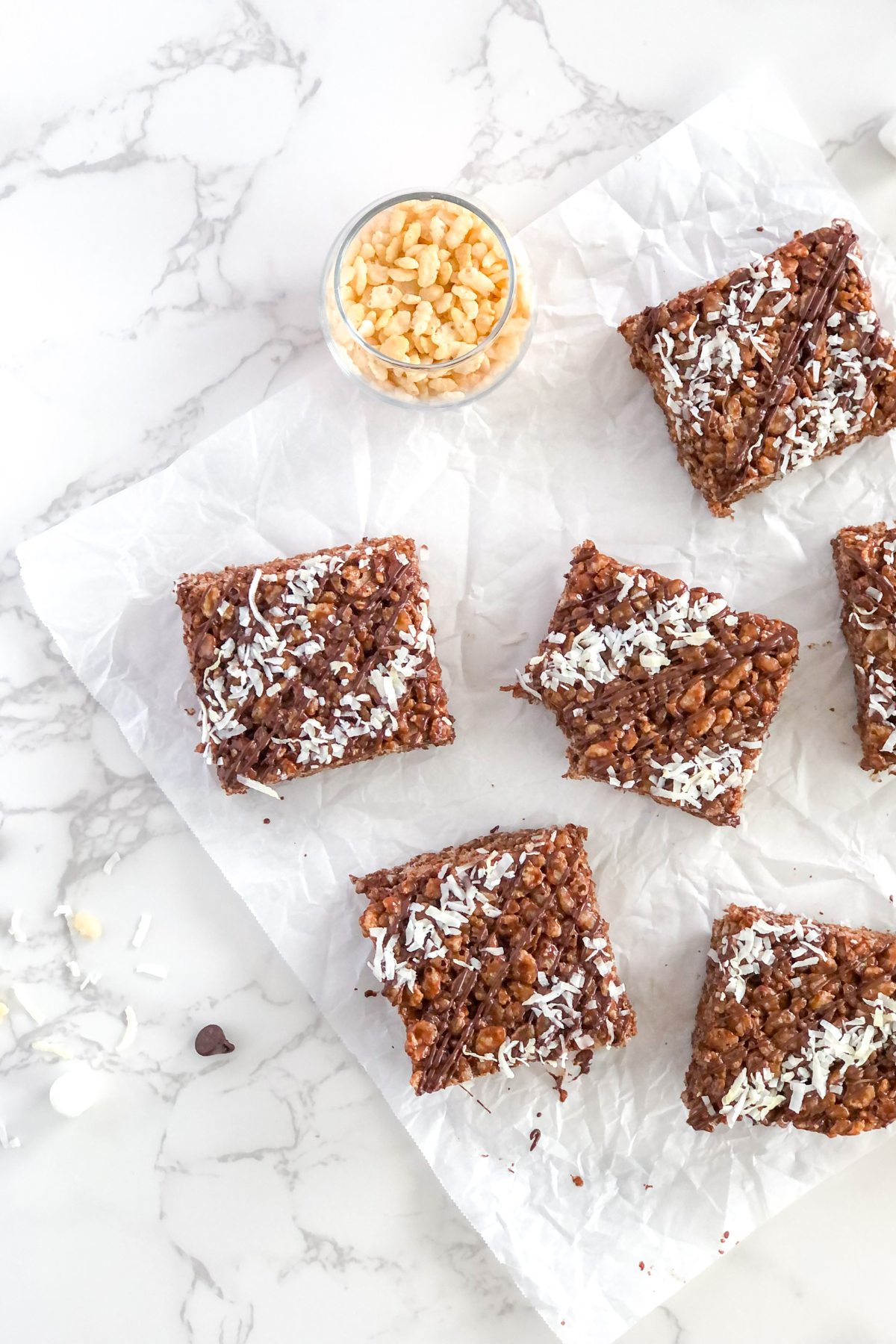 chocolate rice krispie treats with coconut on crinkled parchment paper