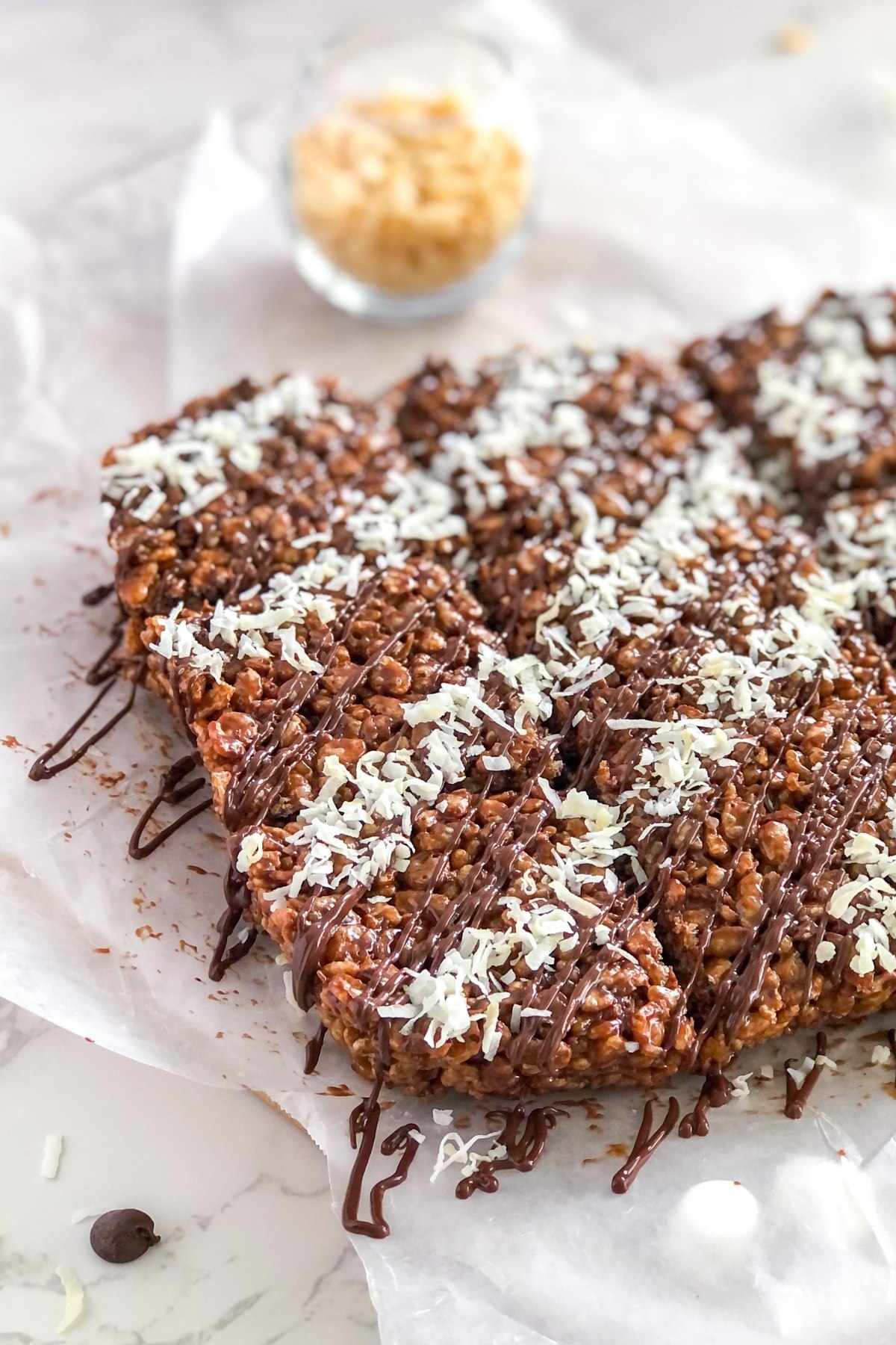 chocolate cereal bars with melted chocolate drizzle and shredded coconut on top