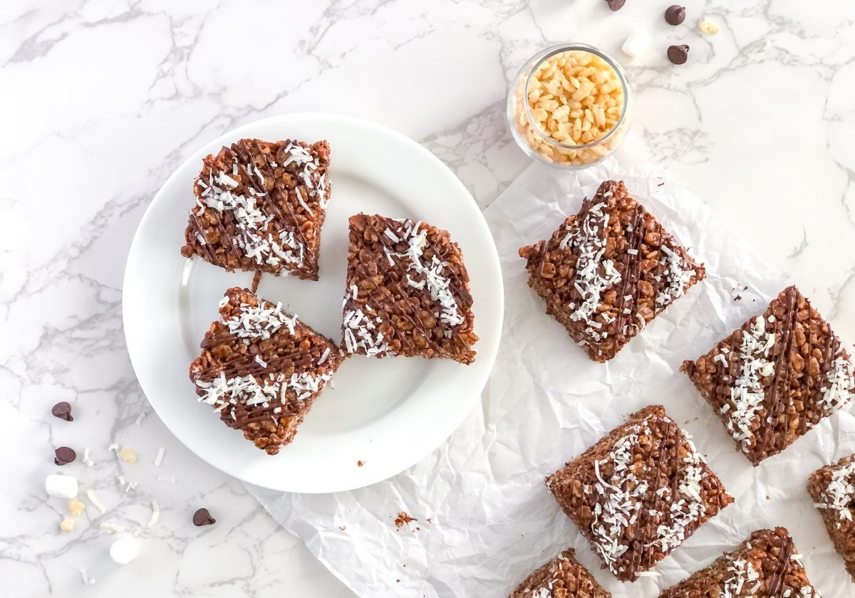 rice krispie treats with cocoa powder and shredded coconut on a plate