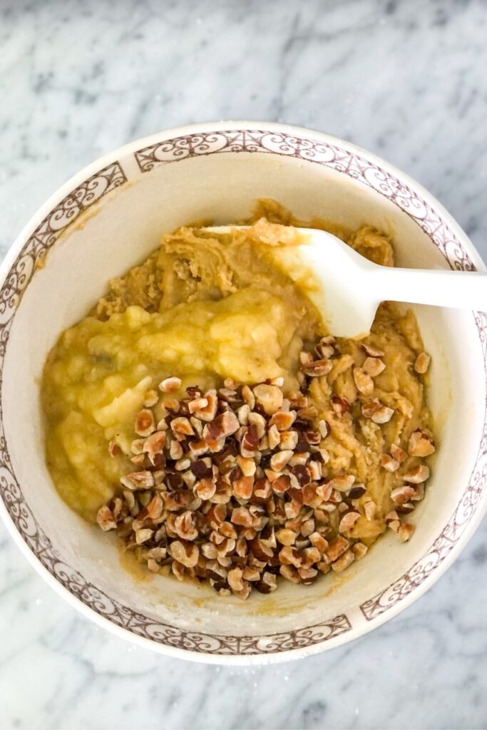 batter with mashed banana and hazelnuts in a bowl