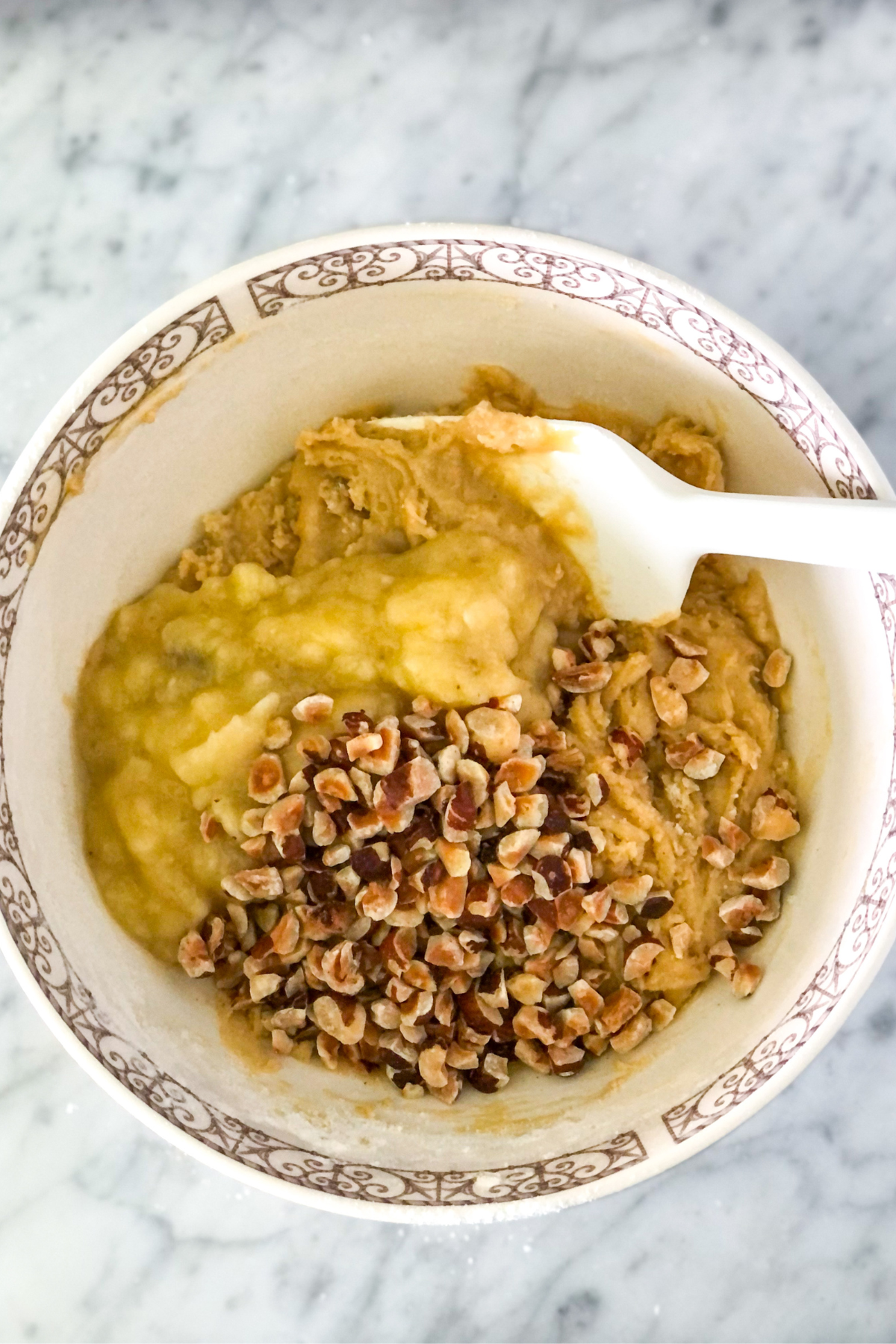 batter with mashed banana and hazelnuts in a bowl