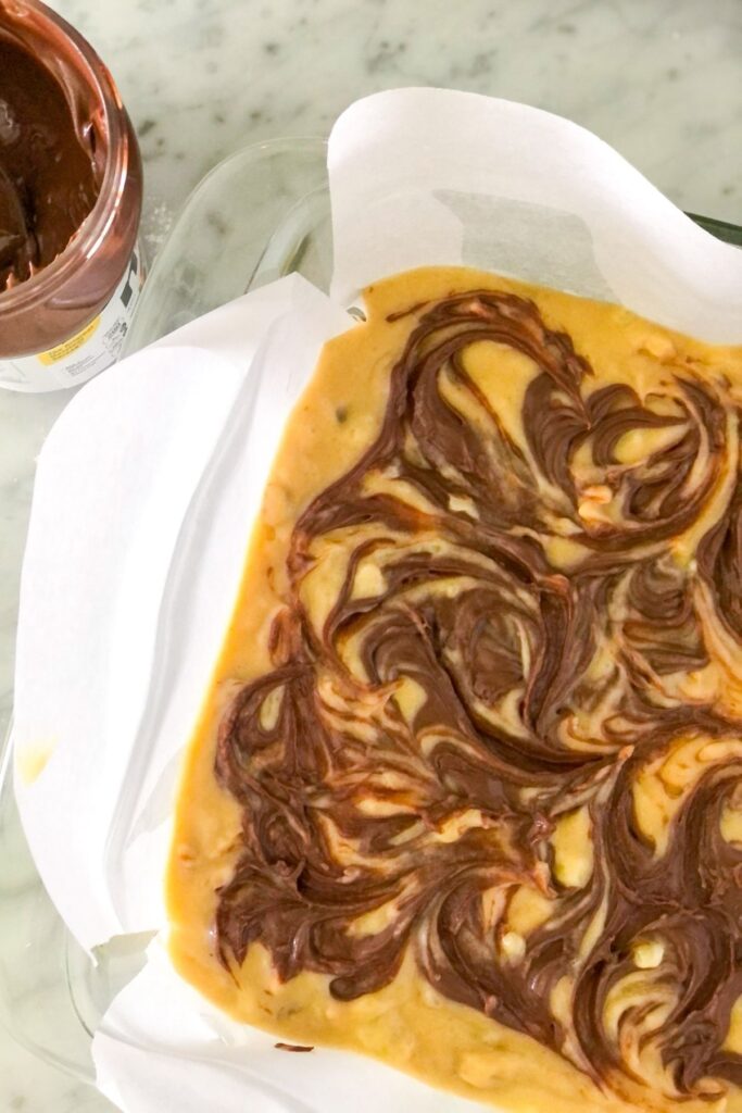 batter with a Nutella swirl in a glass baking dish