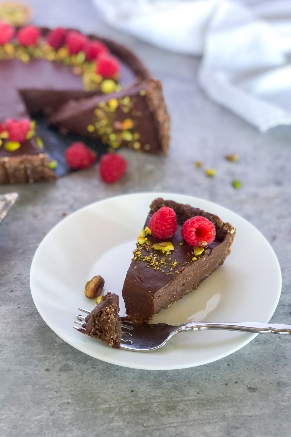 slice of chocolate raspberry tart with pistachios
