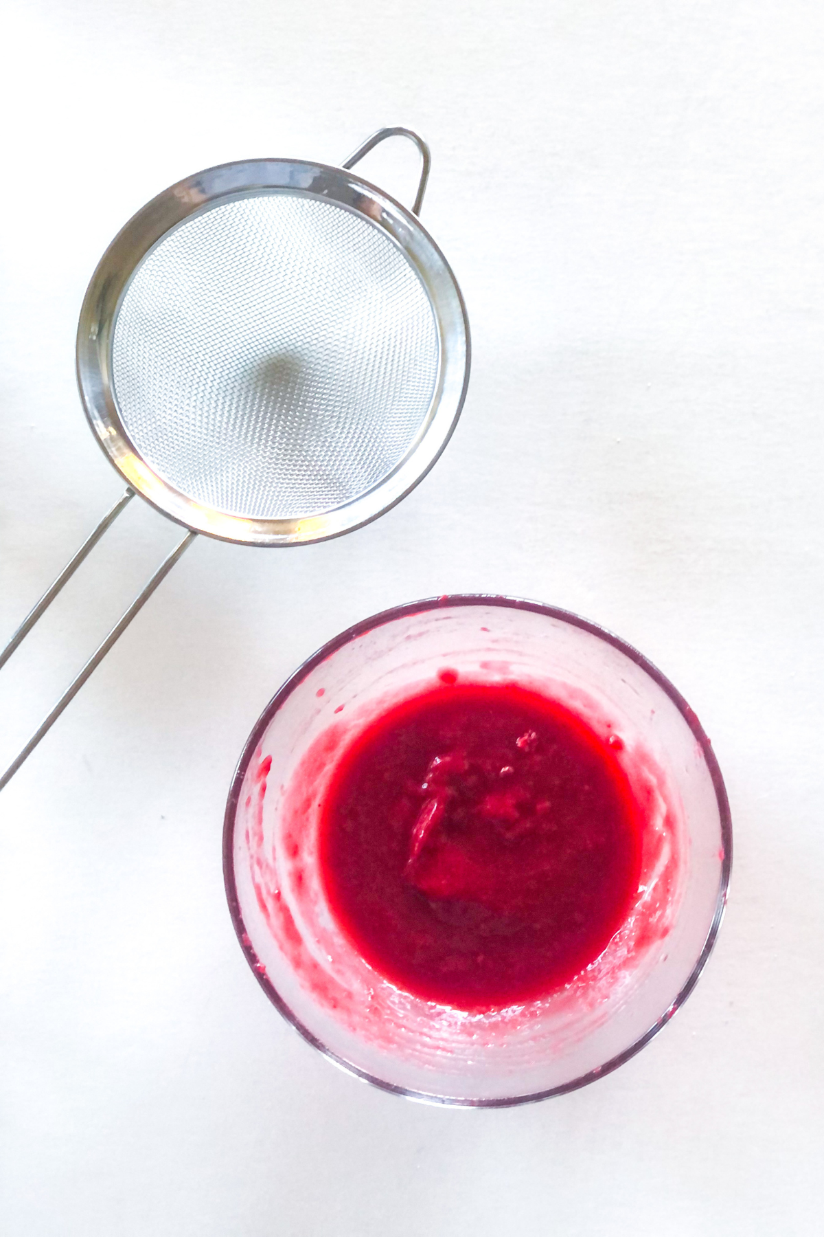 raspberry puree with a sieve
