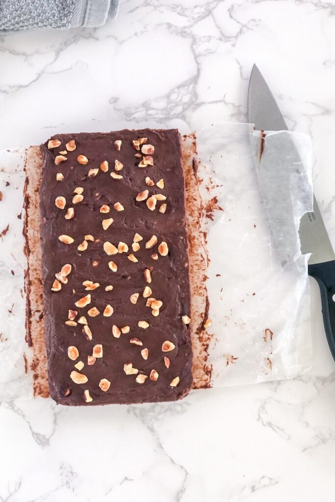 chocolate hazelnut fudge on parchment paper with a knife beside it