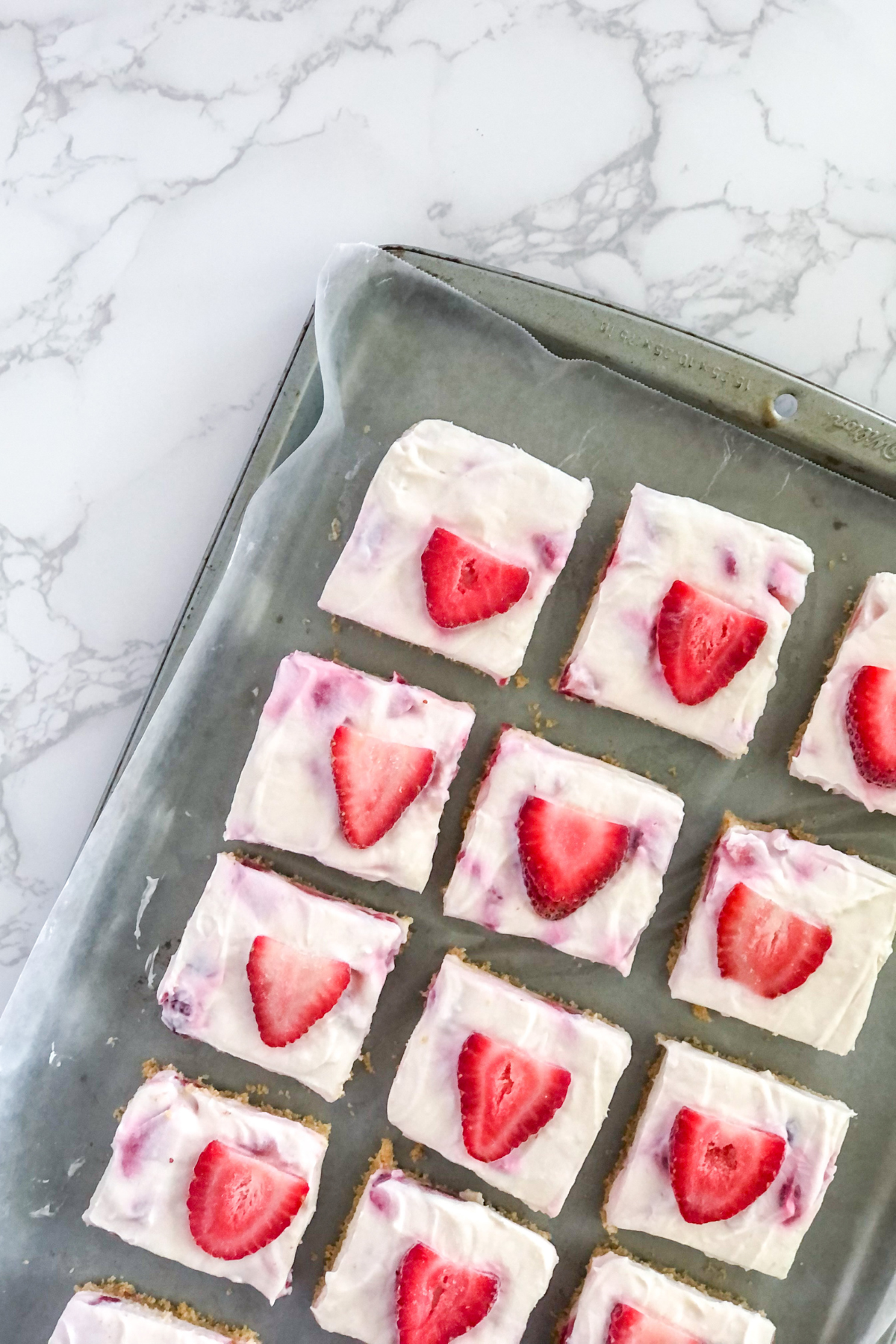 no bake strawberry white chocolate cheesecake bars on wax paper