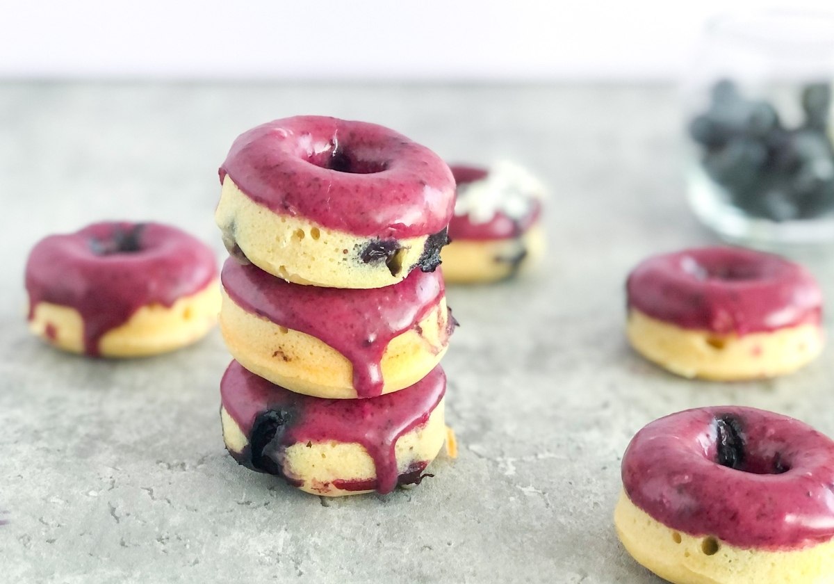 a stack of mini blueberry glazed donuts