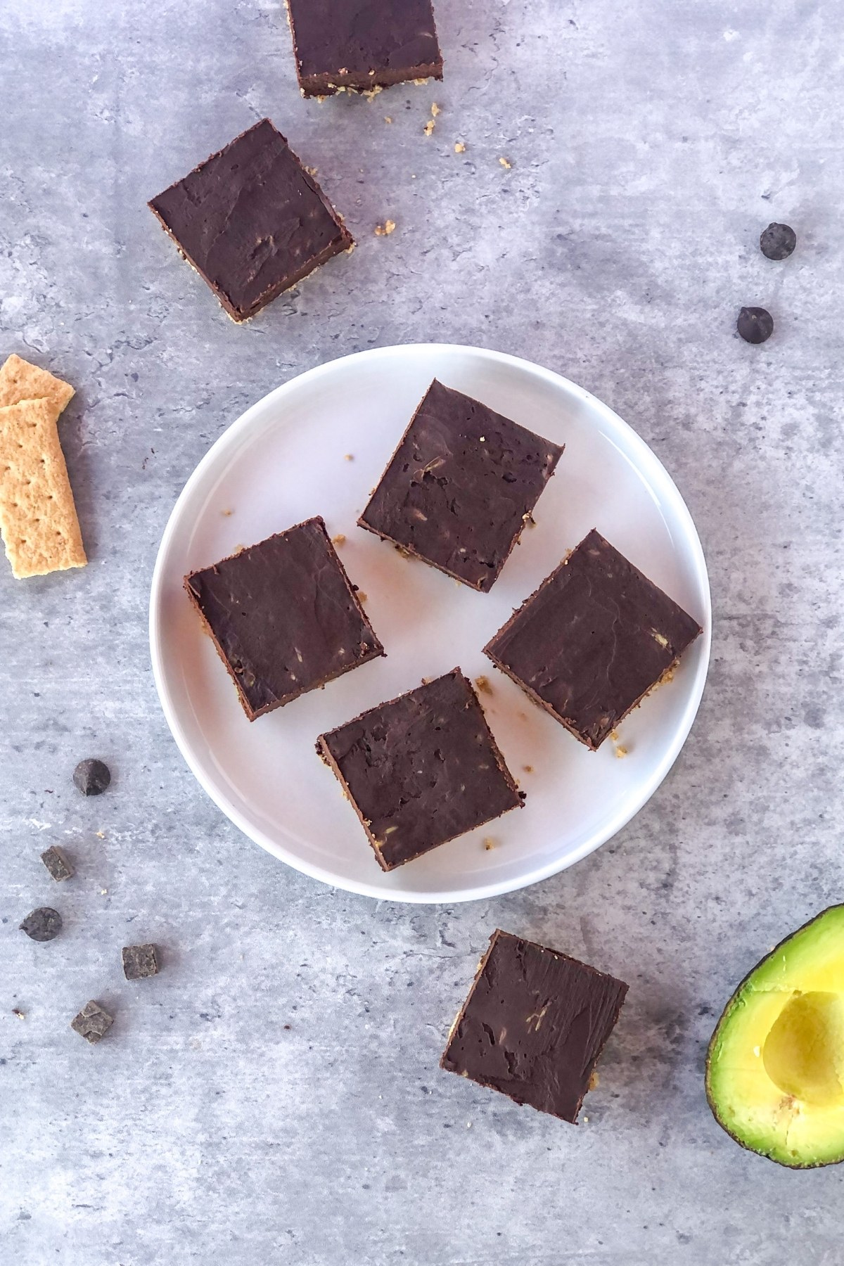 chocolate avocado squares on a plate with graham crackers