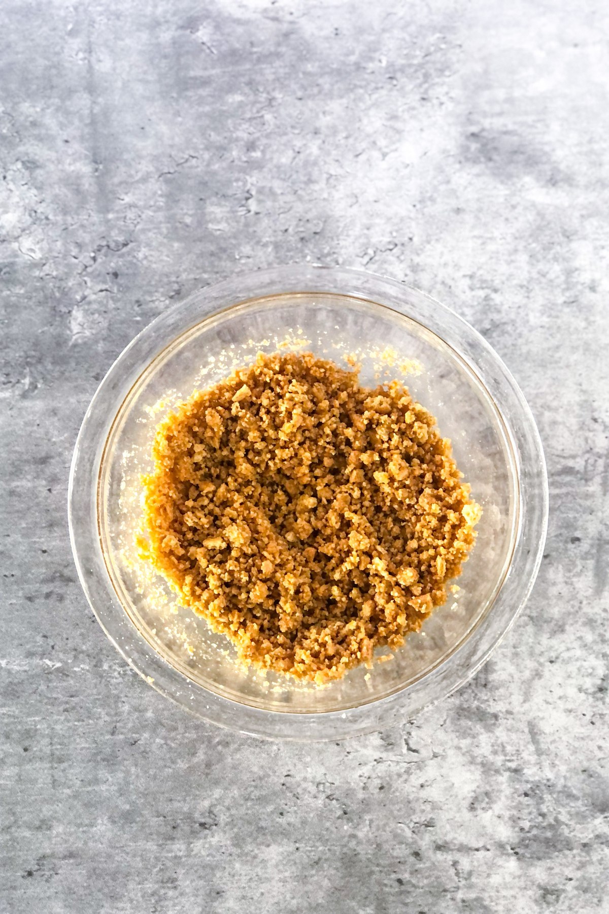 crushed graham crackers and melted butter in a glass bowl