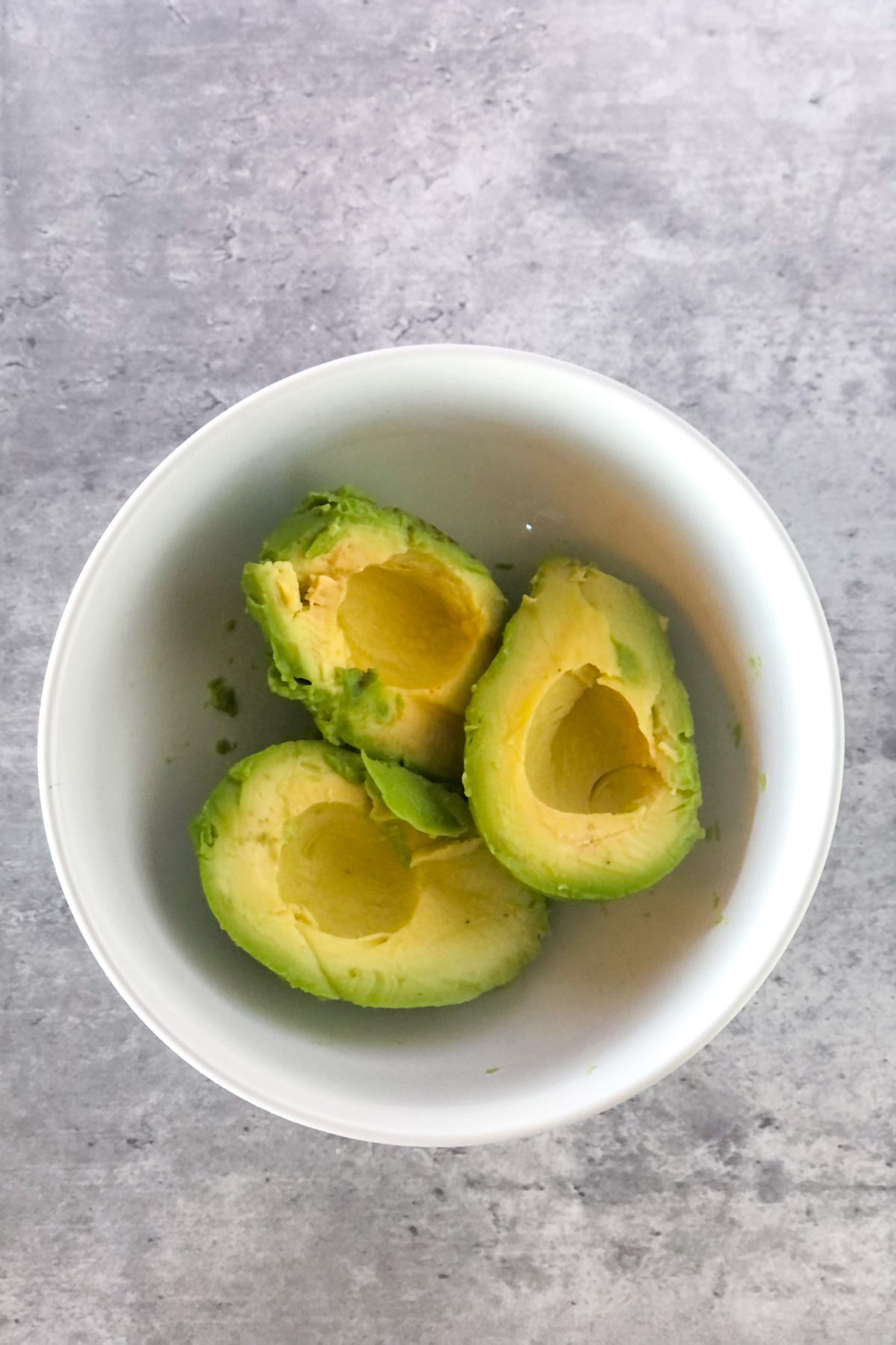 avocado halves in a white bowl