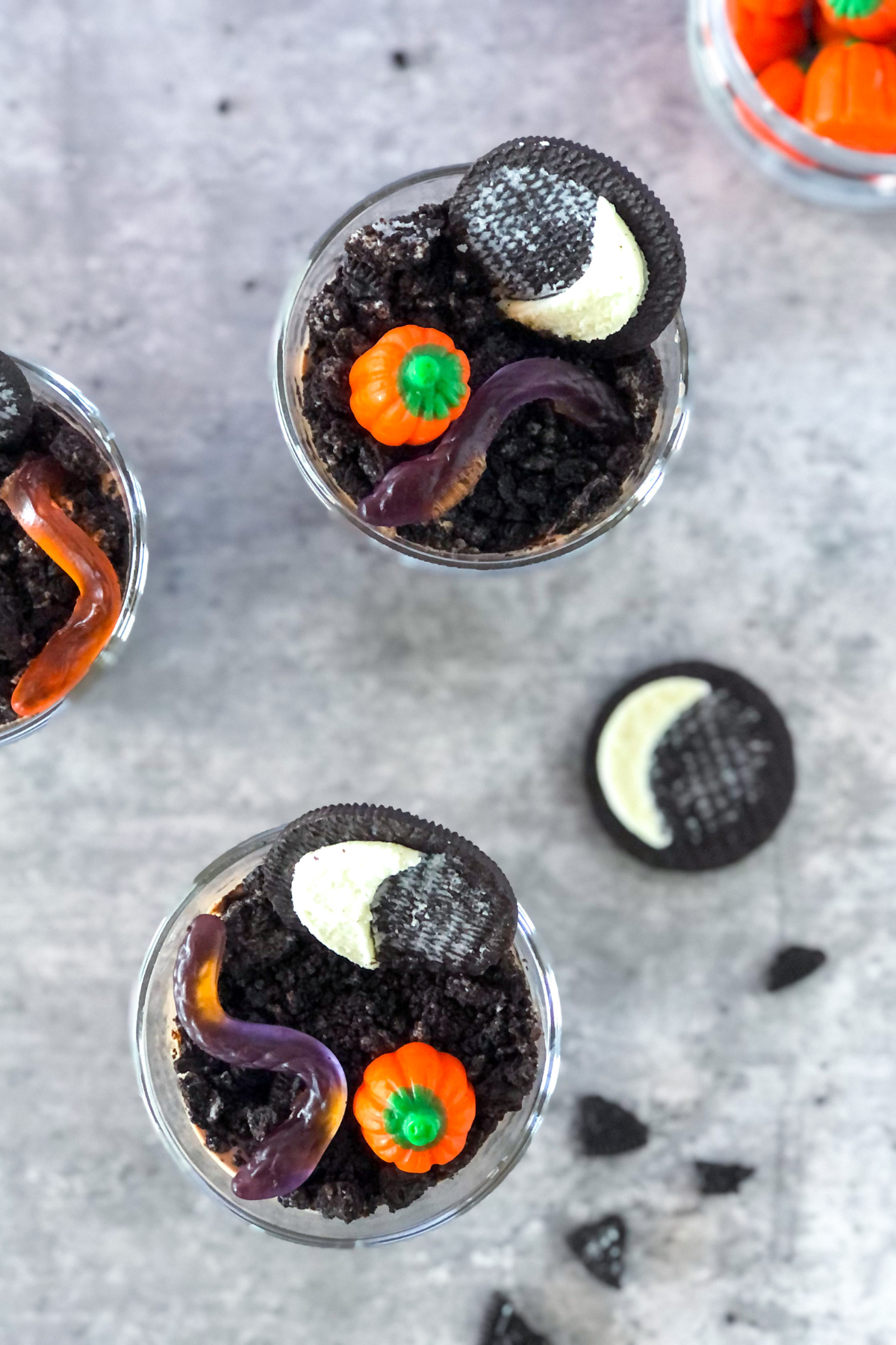 Halloween Oreo dirt cups with candy pumpkins and gummy worms