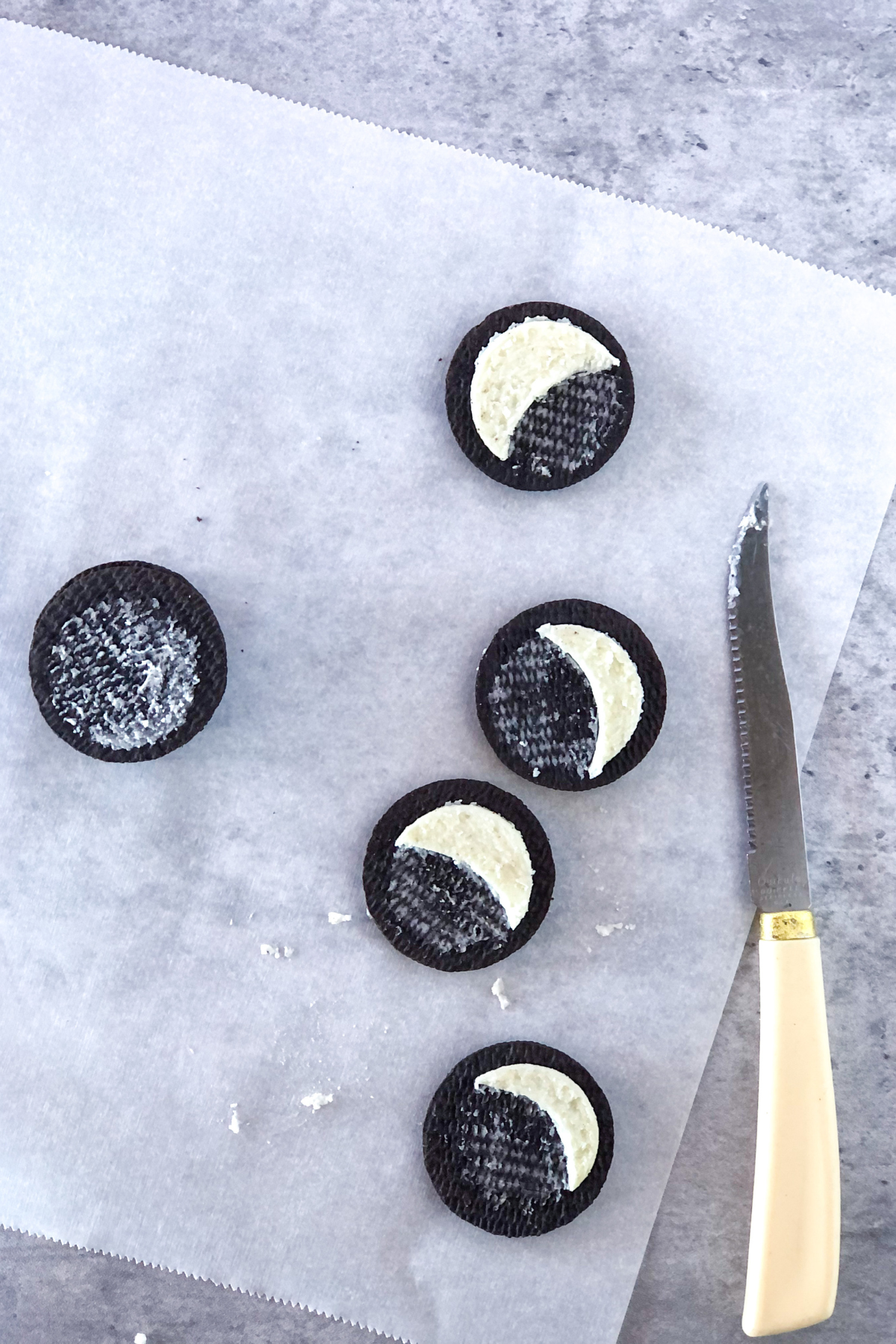 Oreo cookie halves with half moons carved into the cream centers