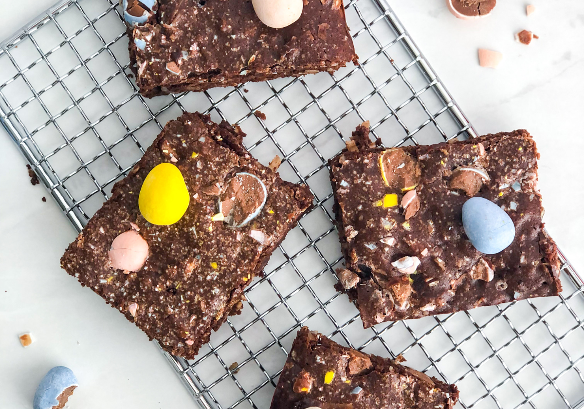 coconut brownies with mini chocolate eggs on a wire cooling rack