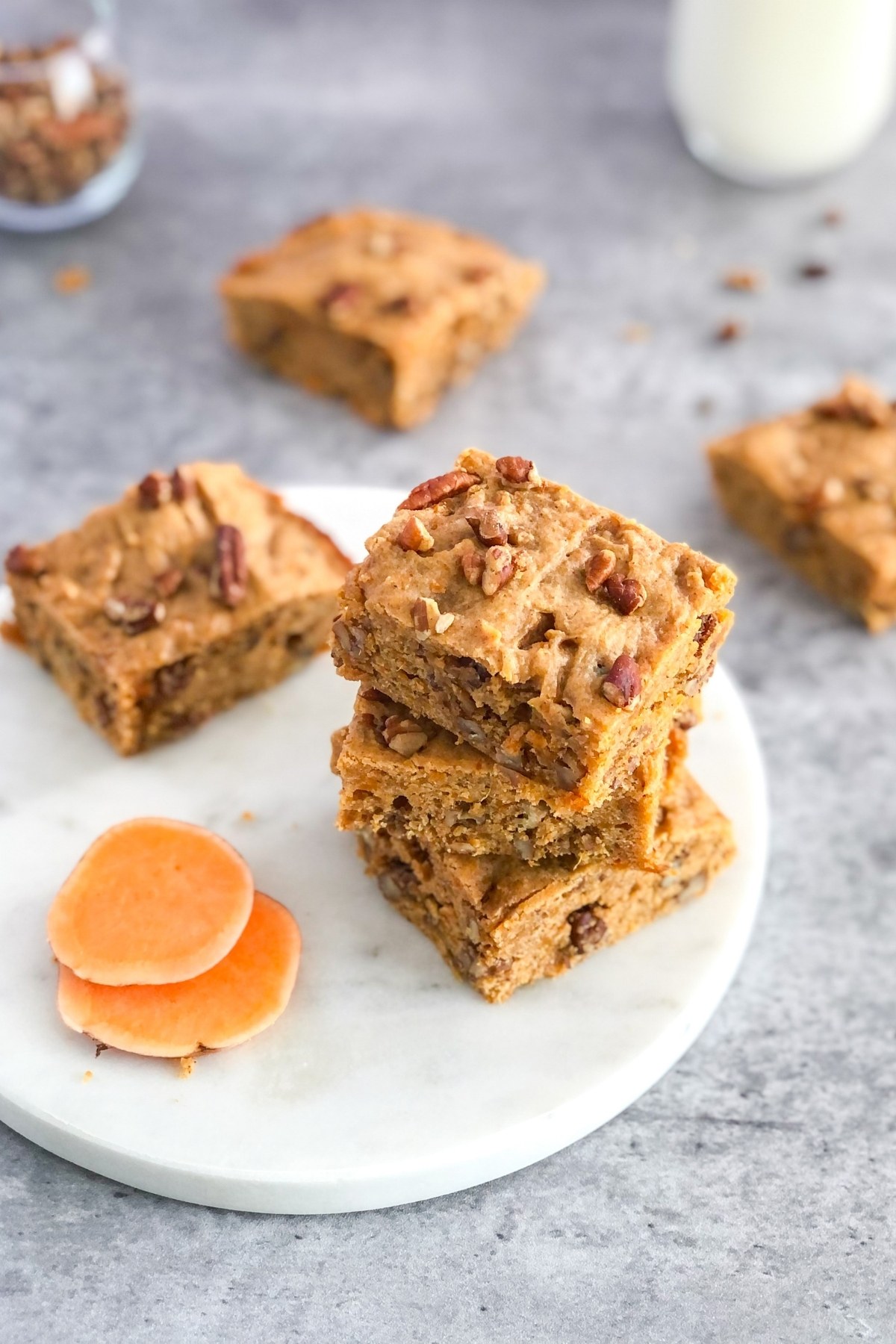 stack of sweet potato blondies with pecans on a marble platter