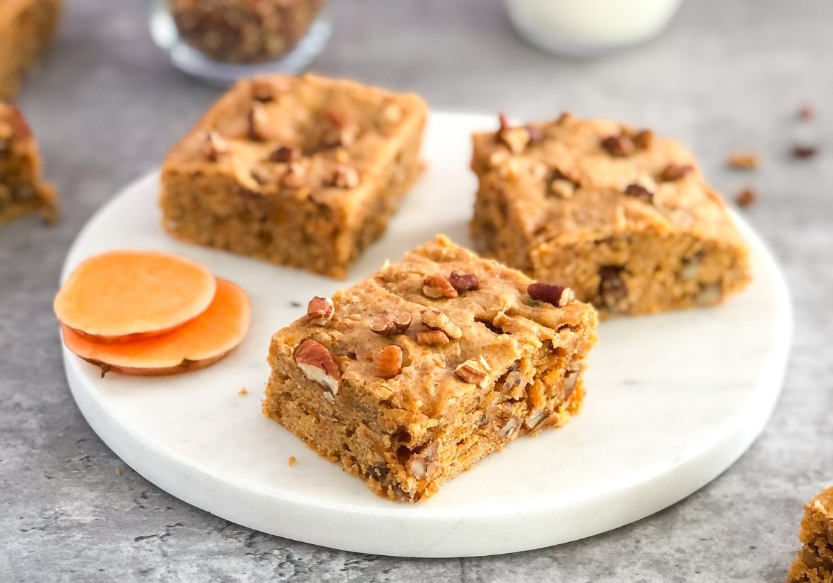 sweet potato bars with pecans on a white marble platter