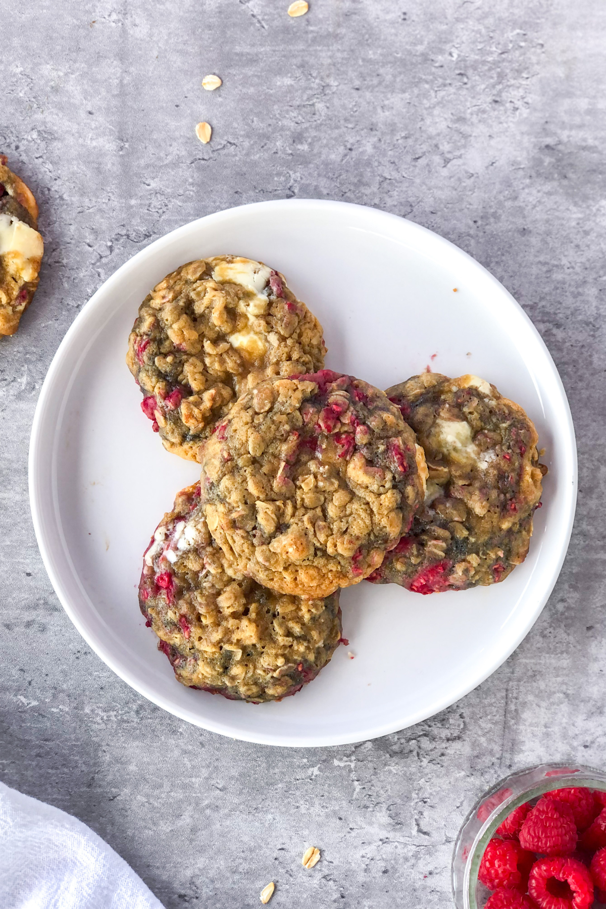 raspberry white chocolate cookies with oats and a bowl of raspberries