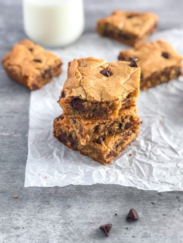 stack of chocolate chip almond butter cookie bars on parchment paper