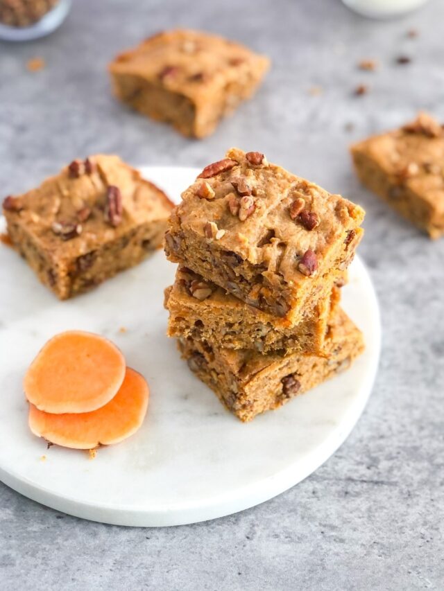 stack of sweet potato blondies with pecans on a marble platter