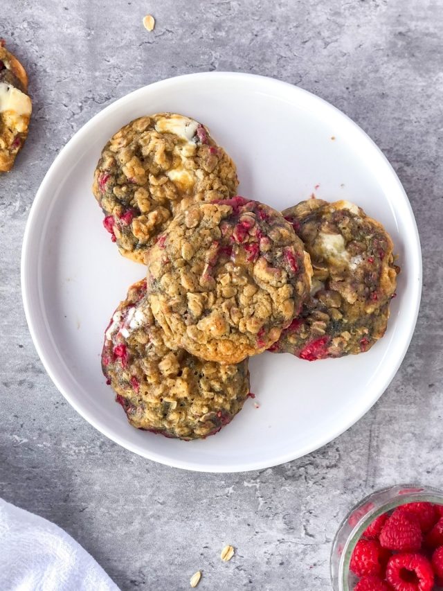 raspberry white chocolate cookies with oats and a bowl of raspberries