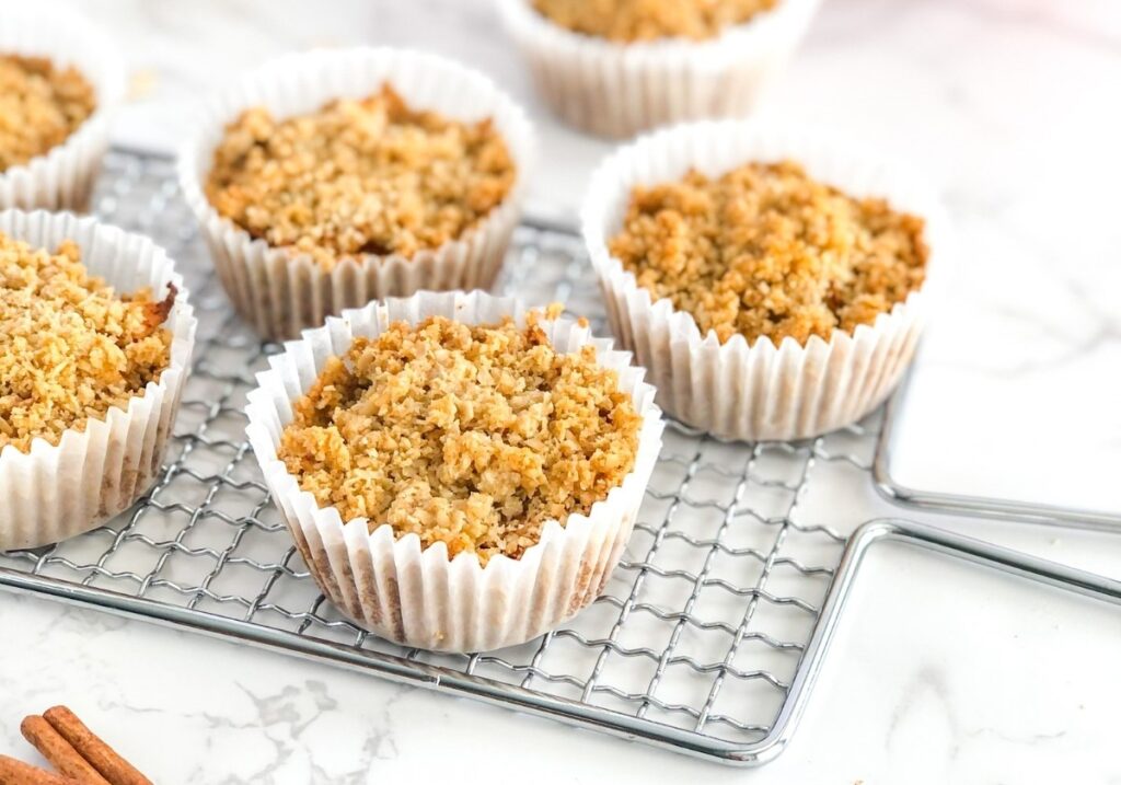 mini cinnamon apple tarts with crumb topping sitting on a wire cooling rack