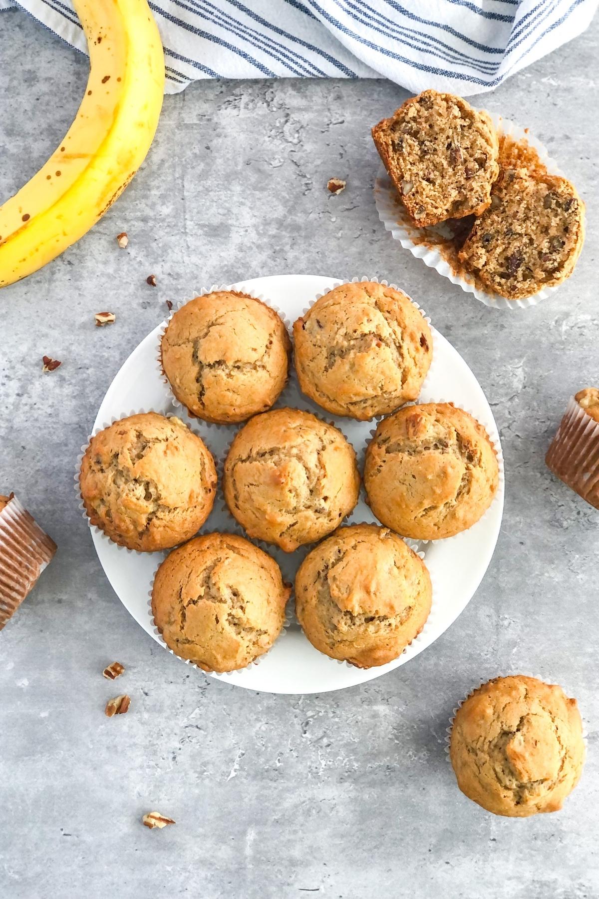 cookie butter and banana pecan muffins on a plate with a striped kitchen towel