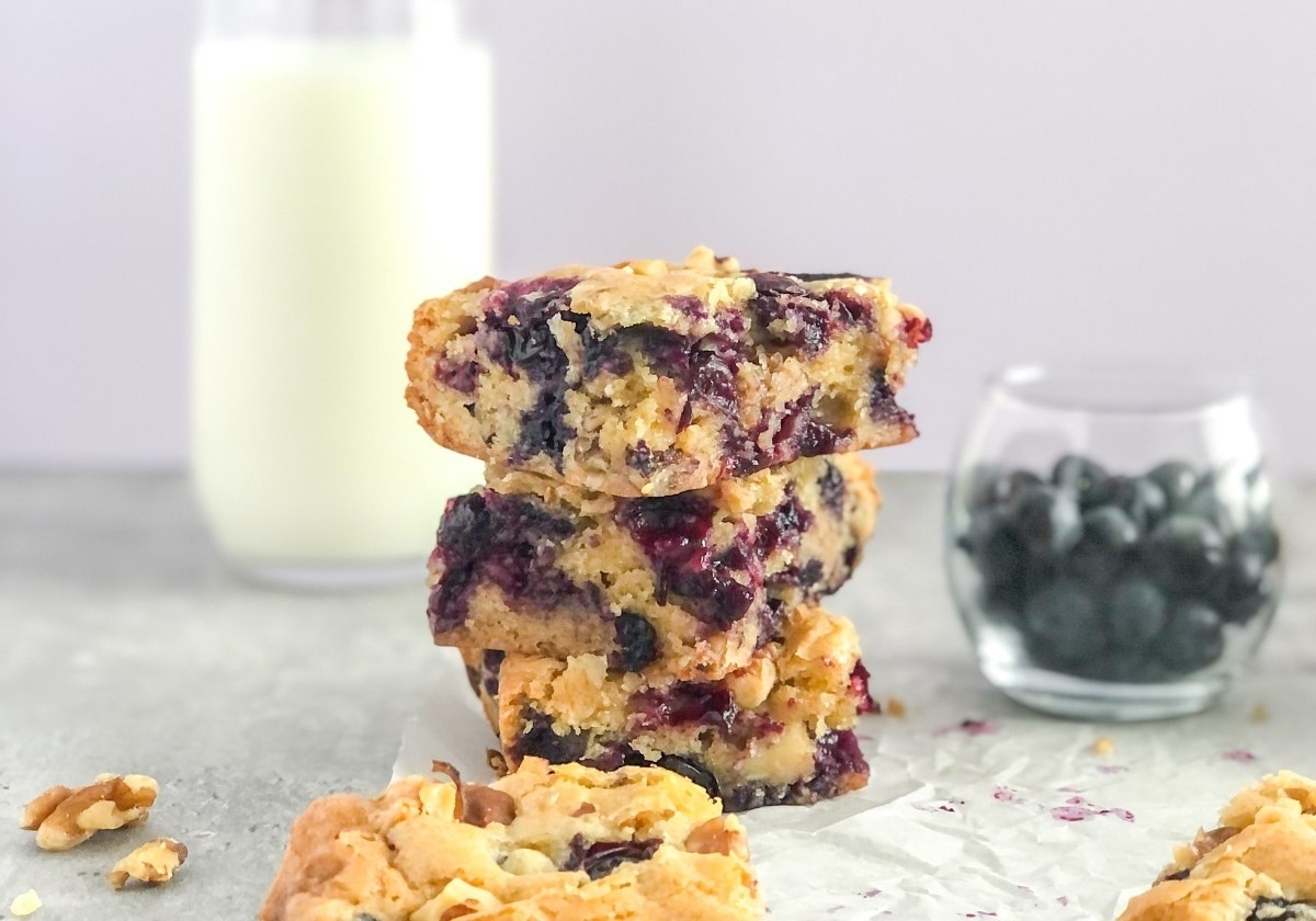 stack of blueberry walnut bars with a glass of milk